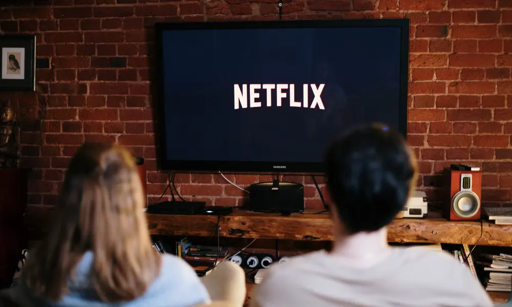 カップルがNetflixを視聴している。生活の中で英語を見聞きする機会が増えたイメージ。