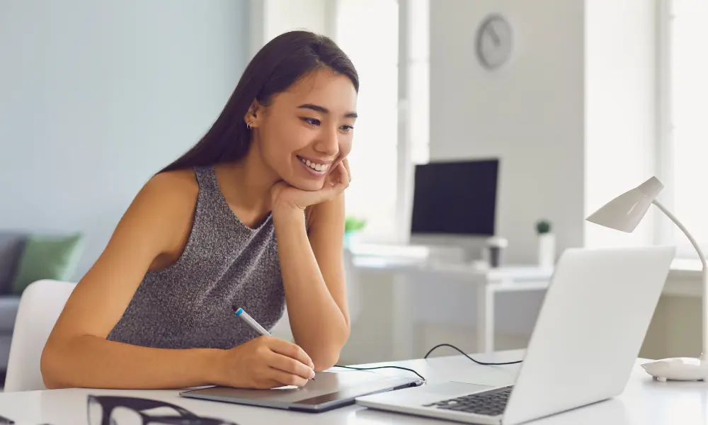 PCの画面を見ながら勉強する女性。楽しく学んでいる様子。