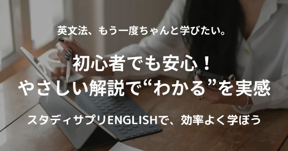 窓際の木のテーブルで、タブレットとスマートフォンを使って英語学習をする女性の手元。そばには温かそうなコーヒーカップが置かれている。