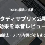 パソコンとスマホ、英語のテキストを広げてTOEICの勉強をしている女性