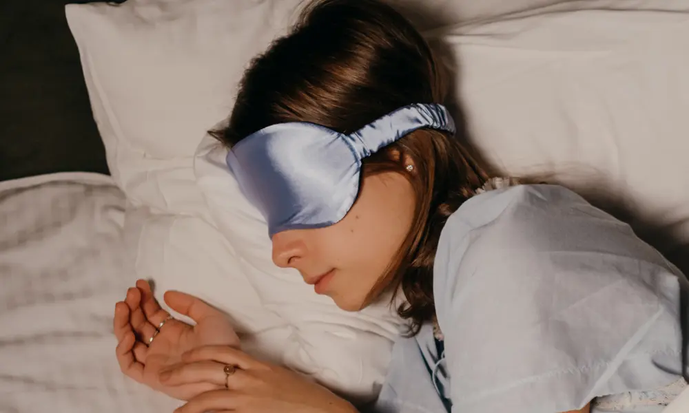 アイマスクをして横になり、眠っている女性