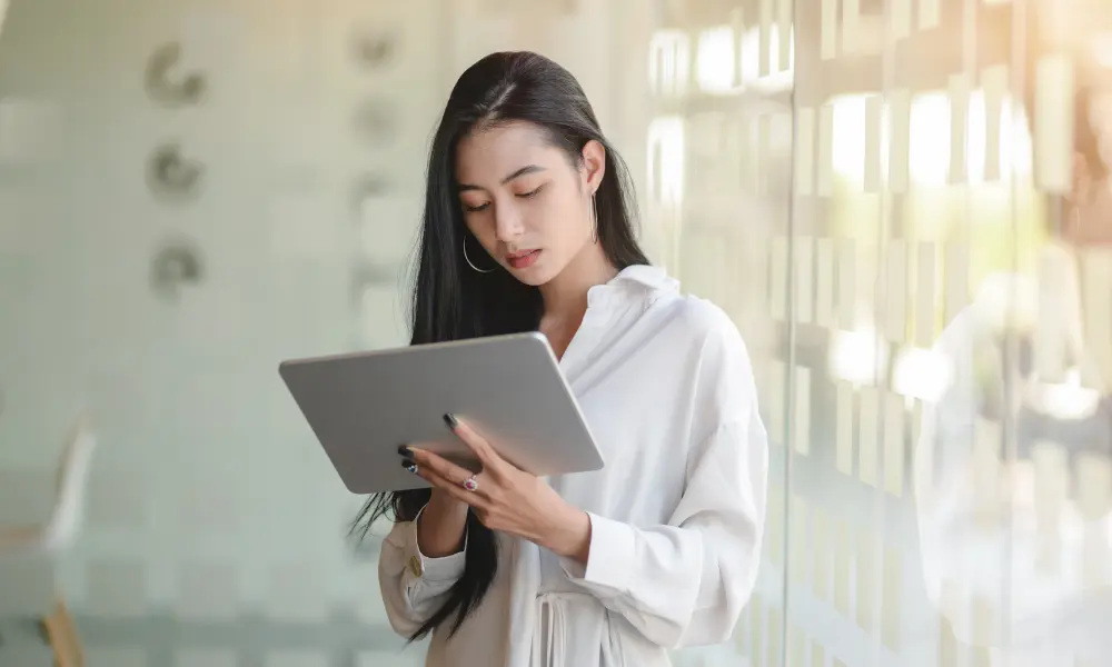 スタディサプリの講義動画をタブレットで視聴している女性。英語学習に集中している様子。