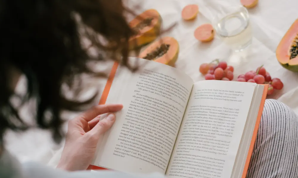英語の本を読んでいる30〜40代の女性。まずは意味をしっかり理解することで音読の効果アップを狙う