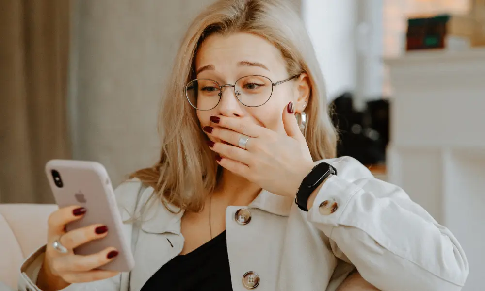 スマホ画面を見て驚く女性の表情。「No way!」と反射的に反応する瞬間を表現
