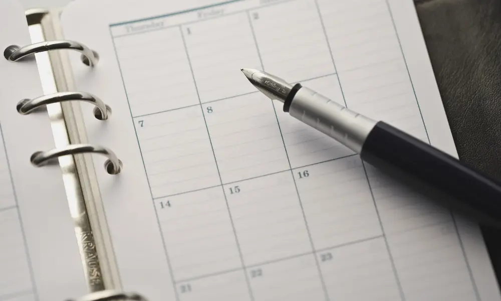 スケジュール帳を開き、英語学習の計画を立てているイメージの写真。