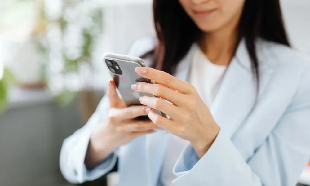 スマホでAI英会話アプリを開いている女性。スキマ時間に英語を話す練習をしようとしている